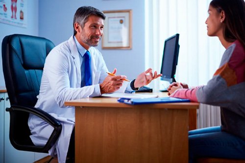 Врач сидит за рабочим столом Консультация у пациента